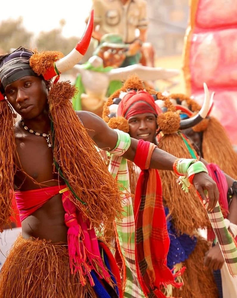 Dançarinos em traje de festa, saias de ráfia e toucados com cornos, numa festa tradicional na Guiné-Bissau