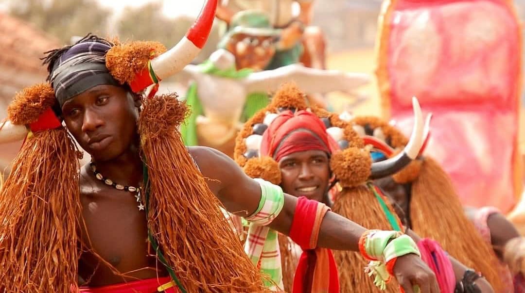 Dançarinos em traje de festa, saias de ráfia e toucados com cornos, numa festa tradicional na Guiné-Bissau